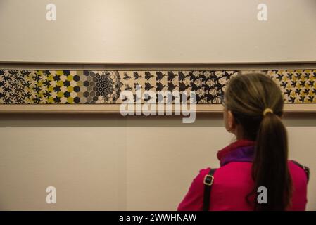 Besucher mit Blick auf „Metamorphose II“ des niederländischen Künstlers Escher in der Ausstellung Stockfoto