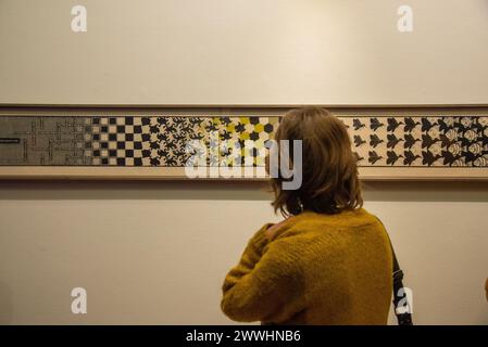 Besucher mit Blick auf „Metamorphose II“ des niederländischen Künstlers Escher in der Ausstellung Stockfoto