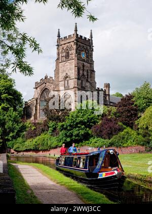 Schmalboot fährt in die Schleuse am Staffordshire and Worcester Canal in Kidderminster, mit St. Mary's Church im Hintergrund, England, Großbritannien Stockfoto