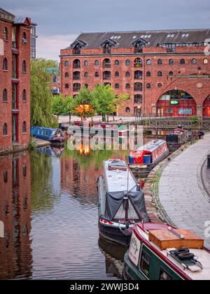 Vertäute Schmalboote im Castlefield Basin zwischen den imposanten viktorianischen Lagerhäusern am Bridgewater Canal in Manchester England, Großbritannien Stockfoto