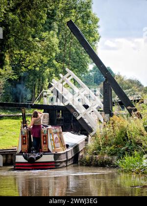 Historisches Schmalboot, das durch eine Liftbrücke und in eine enge Schleuse auf dem Northampton Canal, England, Großbritannien, Northamptonshire fährt Stockfoto