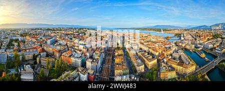 Blick auf die Skyline von Genf in Richtung Jet d'Eau-Brunnen im Genfer See in der Abenddämmerung. Stockfoto