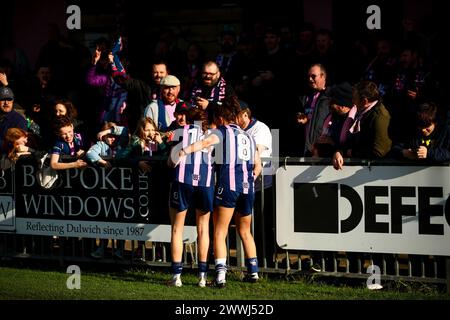 London, Großbritannien. März 2024. Ceylon Hickman (13 Dulwich Hamlet) und Brit Saylor (8 Dulwich Hamlet) warten auf die Nachricht eines weiteren Spiels in der Liga mit ihren Fans („The Pepper Army“), nachdem sie das Spiel in der London and South East Regional Womens Premier League zwischen Dulwich Hamlet und Sutton United in Champion Hill gewonnen haben. Quelle: Liam Asman/Alamy Live News Stockfoto