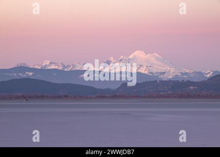 MT Baker badete an einem Winterabend im pastellfarbenen Licht des Sonnenuntergangs vom English Boom Park auf Camano Island im Bundesstaat Washington Stockfoto