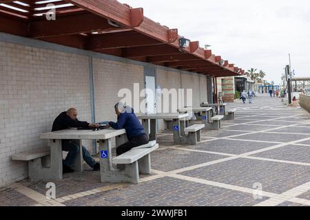 Haifa, Israel - 20. März 2024 spielen zwei Männer am Strand an einem Tisch Backgammon Stockfoto