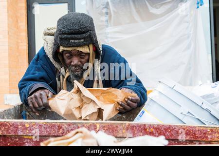 Obdachloser afroamerikanischer Mann New York City, USA. Obdachloser afroamerikanischer Mann, der einen Müllcontainer nach Essensresten sucht. New York City Harlem New York Vereinigte Staaten von Amerika Copyright: XGuidoxKoppesx Stockfoto