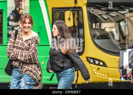 Straßenporträt einer glücklichen, stilvollen Frau mit ihrem Freund gegen den Dublin Bus, der Freude in der lebhaften Straße von Irlands Hauptstadt ausstrahlt. Dublin. Irland Stockfoto