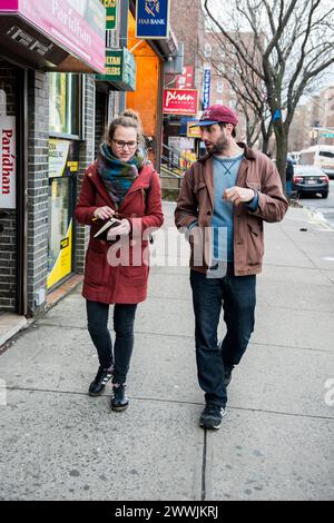 Mann und Frau Bronx, New York City, New York, USA. Straßenporträt eines jungen Asult männlichen, der mit einer weiblichen Journalistin durch die Straßen der Stadt wandert. MRYES New York City Roosevelt Avenue, Queens New York Vereinigte Staaten von Amerika Copyright: XGuidoxKoppesx Stockfoto