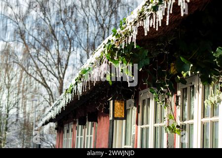 Altes Stadthaus mit Eiszapfen und Schnee Stockfoto