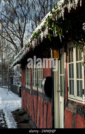 Altes Stadthaus mit Eiszapfen und Schnee Stockfoto