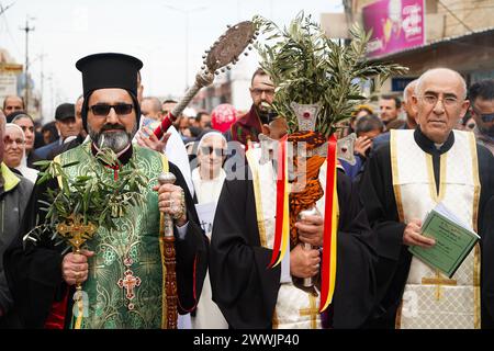 Al Hamdaniya, Irak. März 2024. Der syrisch-katholische Erzbischof von Mossul und seine Abhängigkeiten, Bischof Mar Benedikt Younan Hanno (L), nimmt an der Palmensonntagsprozession im Bezirk Al-Hamdaniya Teil, auch bekannt als Qaraqosh, etwa 35 km südöstlich von Mossul. (Foto: Ismael Adnan/SOPA Images/SIPA USA) Credit: SIPA USA/Alamy Live News Stockfoto