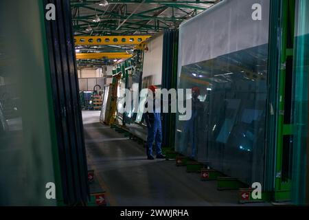 Foreman inspiziert Glas in einer Fensterfabrik Stockfoto