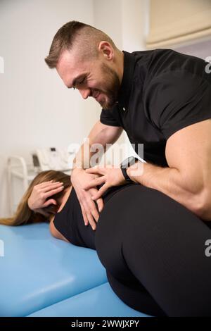 Die Massagetherapeutin in einem Wellnesscenter arbeitet mit der weiblichen Wirbelsäule Stockfoto