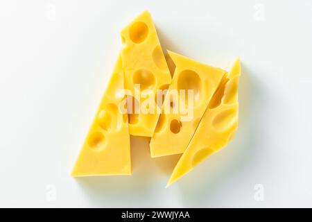 Käse mit großen Löchern auf weißem Hintergrund. Kunstkonzept Stockfoto