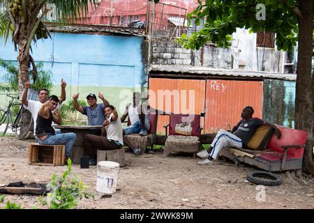 Junge Männer mit Daumen hoch, die an einem warmen Tag in einem Park in Havanna, Kuba, Dominospiele spielen. Stockfoto