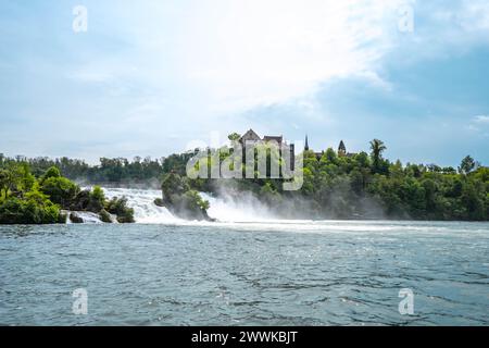 Beschreibung: Touristen beobachten die beeindruckenden Wasserfälle unter Schloss Laufen am Rheinfall von den Felsen und Touristenbooten aus. Rheinfall, Neuhausen Stockfoto