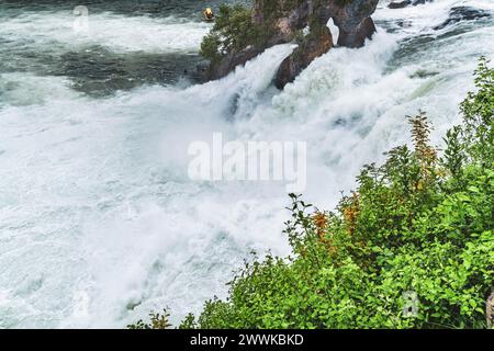 Beschreibung: Touristen beobachten die massiven Wasserfälle unter Schloss Laufen am Rheinfall vom Touristenboot aus. Rheinfall, Neuhausen am Rheinfall, Stockfoto