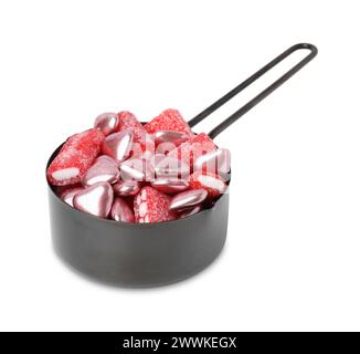 Leckere Bonbons im Messbecher isoliert auf weiß Stockfoto