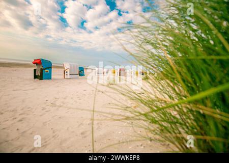 Weiße Sandstrände und Sandgras der Nordsee in Deutschland.Strand grünes Gras und Strandhütten auf weißem Sand auf den Sanddünen im Wind.Strand Stockfoto