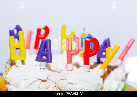 Geburtstagskuchen mit Happy Birthday Kerzen auf weißem Hintergrund Stockfoto