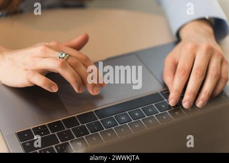 Hände einer Frau, die formell in einem hellblauen Hemd gekleidet ist und auf ihrem Laptop schreibt Stockfoto