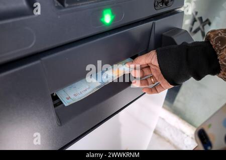 Eine Frau, die Geld abhebt, Rupiah vom Geldautomaten in Indonesien. Stockfoto