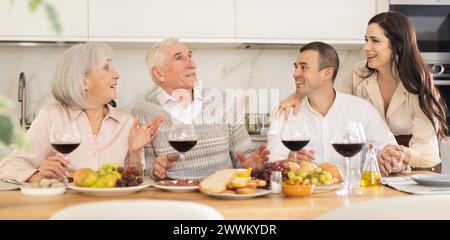 Seniorenpaar mit erwachsenem Sohn und Schwiegertochter genießen das Abendessen Stockfoto