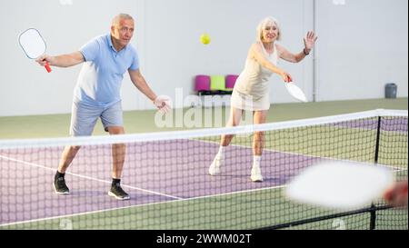 Alter Mann und Frau spielen freundliche Doppel-Pickleball Stockfoto