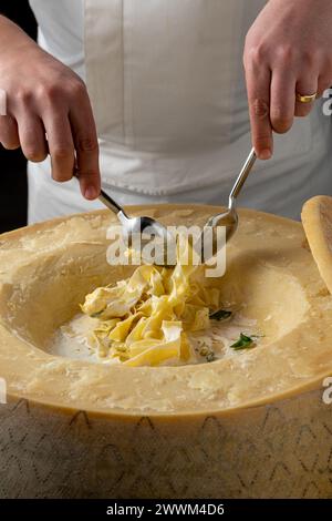Frische Pasta mit Sauce in einem ganzen Parmesanrad Stockfoto