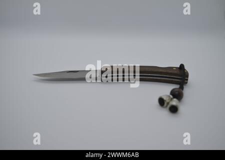 Ein offenes Taschenmesser auf weißem Hintergrund, das seine scharfe Klinge und sein vielseitiges Design für verschiedene Aufgaben freigibt. Stockfoto