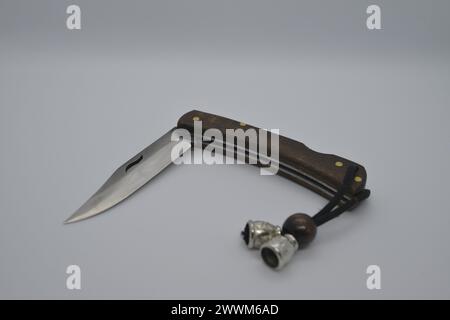 Ein offenes Taschenmesser auf weißem Hintergrund, das seine scharfe Klinge und sein vielseitiges Design für verschiedene Aufgaben freigibt. Stockfoto