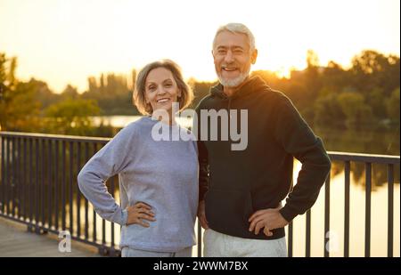 Reifes glückliches Paar, das im Stadtpark steht, nachdem er Sport in der Natur trainiert hat. Stockfoto