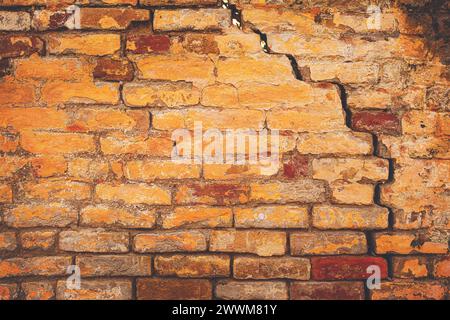 Beschädigte Risse der alten Ziegelmauerstruktur, aufgrund von Versagen des Baugrundes und Verschlechterung der Baumaterialien als städtischer Hintergrund Stockfoto