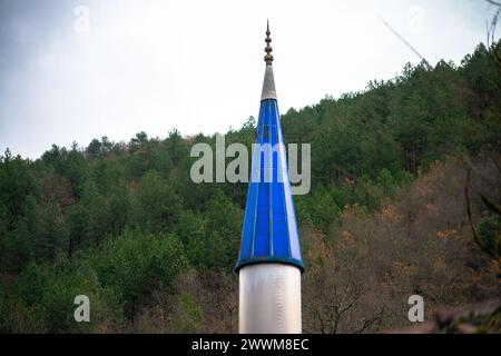 Die schlanke Spitze eines blauen Minaretts reicht zum Himmel, verziert mit komplizierten Details, die die Eleganz der islamischen Architektur verkörpern. Stockfoto