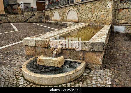 Der alte Brunnen, der heute restauriert wurde, dient auch als öffentliches Waschhaus und Trinkrinne für Tiere in Casale Cocullo. Cocullo, Abruzzen Stockfoto