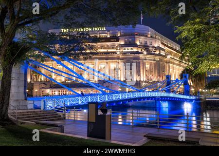 Singapore River mit der Cavenagh Bridge und dem Fullerton Hotel in Singapur, während der abendlichen Atmosphäre Stockfoto