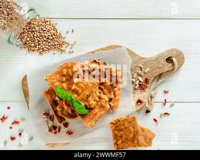 Glutenfreie Knäckebrot aus Buskweizenmehl. Grünes Buchweizenmehl geräuchertes Paprika Sonnenblumenkerne Zutaten hausgemachtes, gebackenes Knäckebrot. Idee Rezept Snacks glutenfreies Konzept. Draufsicht flach liegend Stockfoto