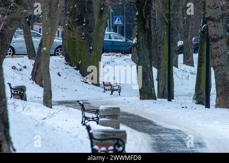 Die schneebedeckten Parkbänke sind auf einem Bürgersteig ausgerichtet Stockfoto