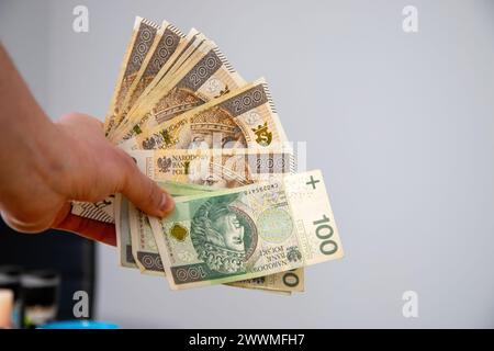Ein Mann, der polnische Währung in der Hand hält Stockfoto