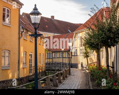 Charmante enge Straße mit Fachwerkhäusern entlang des Kanals in der Altstadt von Bogense, Fünen, Dänemark Stockfoto