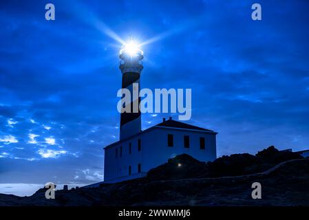 Favàritx Leuchtturm, bei Nacht, mit der Beleuchtung der Lichtstrahlen des Leuchtturms (Menorca, Balearen, Spanien) ESP: Faro de Favàritx Stockfoto