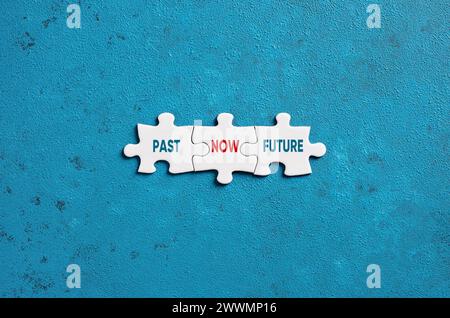 Die Worte Past Now und Future auf Puzzleteilen auf blauem Hintergrund. Zeitmanagement und Zeitplankonzept. Stockfoto