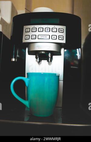 Tasse und schwarze Kaffeemaschine Stockfoto