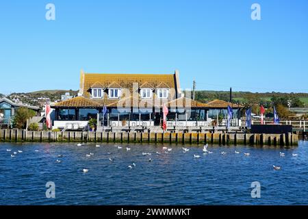Blick auf das Rise Riverside Restaurant in der Stadt in der Nähe des Hafens, West Bay, Dorset, Großbritannien, Europa. Stockfoto