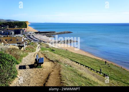 Erhöhte Aussicht über die Dächer der Stadt in Richtung Strand, Klippen und Landschaft vom South West Coast Path, West Bay, Dorset, Großbritannien. Stockfoto