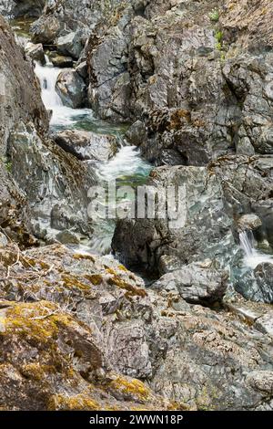 Weißes Flusswasser, das durch die farbenfrohen steilen Wände des Canyons rauscht. Stockfoto