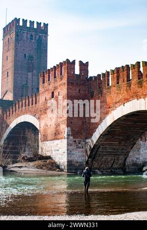 Ein Mann, der im Fluss fischt, unter der alten Brücke in Verona Stockfoto