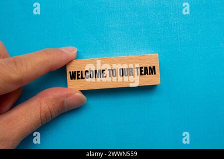 Willkommen zu unseren Teamworten auf Holzblock mit blauem Hintergrund. Konzeptionelles Geschäftssymbol. Kopierbereich. Stockfoto