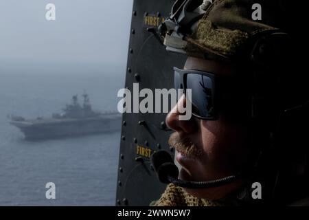 Caleb Edens, ein Infanterie-Marine der 31. Marine Expeditionstruppe, blickt während eines Besuchs in der Philippinischen See von einem UH-1Y Gift auf das Meer 2024. VBSS ist Teil von Seefahrteinsätzen, die darauf abzielen, feindliche Truppen oder Vorräte im maritimen Bereich zu verzögern, zu stören oder zu zerstören. Die 31. MEU arbeitet an Bord von Schiffen der America Amphibious Ready Group im Einsatzgebiet der 7. Flotte, um die Interoperabilität mit Verbündeten und Partnern zu verbessern und als einsatzbereite Eingreiftruppe zur Verteidigung des Friedens A zu dienen Stockfoto