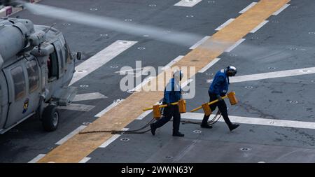 PAZIFIK (16. Februar 2024) Seeleute, die dem vorgelagerten amphibischen Angriffsträger USS America (LHA 6) zugeteilt wurden, entfernen Keile und Ketten während des Flugbetriebs im Pazifischen Ozean am 16. Februar. America, Leitschiff der America Amphibious Ready Group, ist im Einsatzgebiet der 7. US-Flotte im Einsatz. Die 7. US-Flotte ist die größte nach vorne gerichtete nummerierte Flotte der US Navy und interagiert routinemäßig mit Verbündeten und Partnern, um eine freie und offene Region im Indo-Pazifik zu erhalten. Marineblau Stockfoto